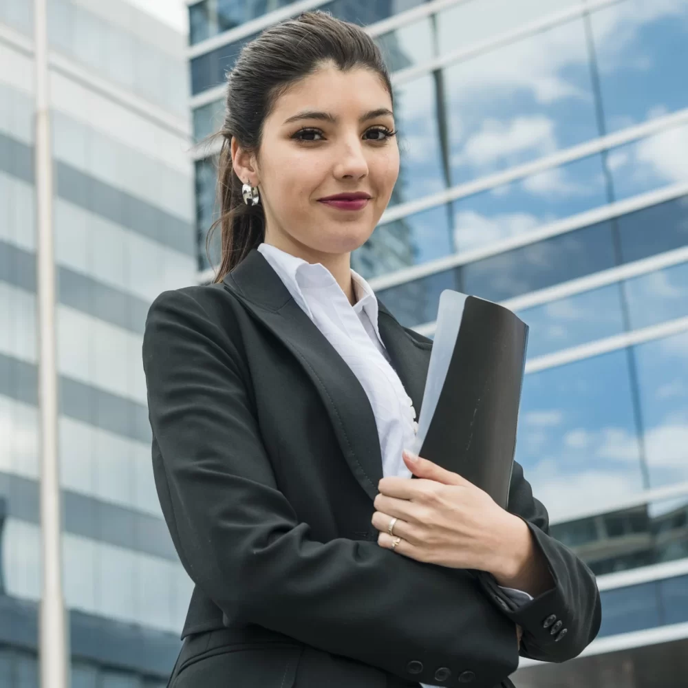 happy-young-businesswoman-holding-folder-standing-front-building